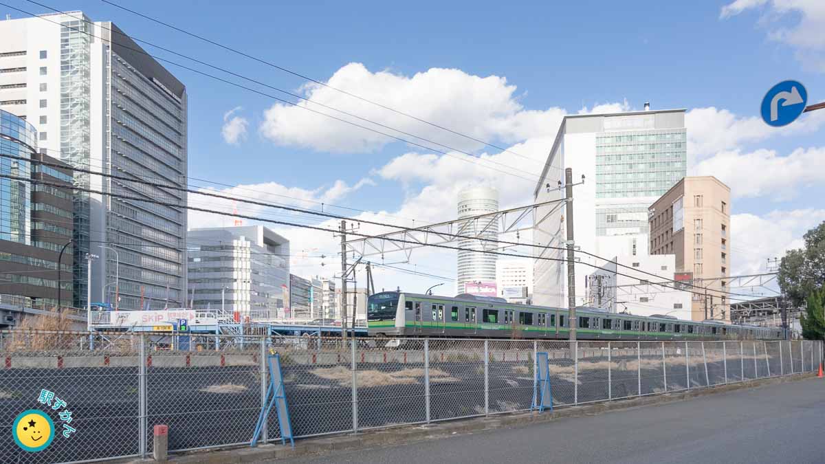 横浜線の電車と新横の街並み